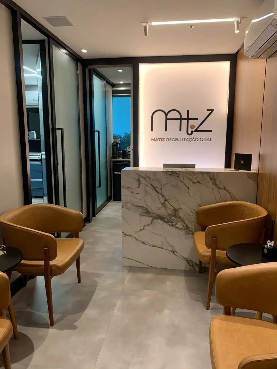 Recepção da Clínica Matiz, com a marca na parede e poltronas de espera